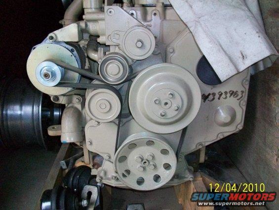 Engine block with belts and pulleys, beige paint, serial number 4393963 visible