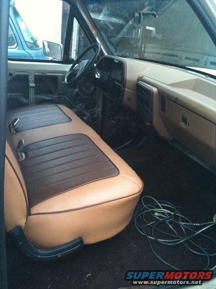 Interior view of a tan and brown bench seat with exposed door panels