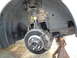 2003 Ford Taurus - Close-up view of a vehicle's front wheel hub and brake assembly, showing the rotor, caliper, and shock absorber.