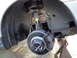 2003 Ford Taurus - Close-up of a vehicle's front wheel hub and brake system, supported by a jack stand.