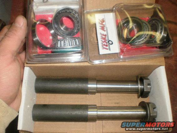 Two metal shafts with nuts and bearings in plastic packaging