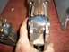 1995 Ford Bronco - A person is holding a metal mechanical component, likely a vehicle part, for inspection.
