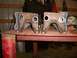 1995 Ford Bronco - Two fabricated suspension components are shown on a table in a workshop.