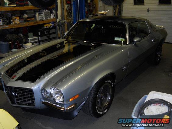 1971 Chevrolet Camaro SS with black racing stripes parked in a garage