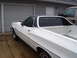 1973 Ford Ranchero - White 1973 Ford Ranchero with a black vinyl top parked in front of a garage.