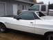 1973 Ford Ranchero - White 1973 Ford Ranchero with a black vinyl top and hood stripe, parked outdoors.