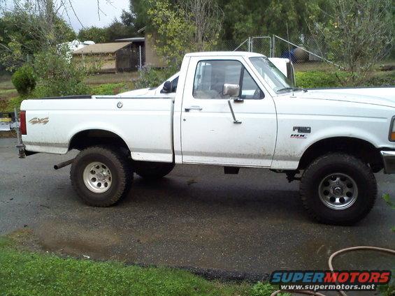 White 1995 Ford F-150 pickup truck, side view. It has a single cab and a long bed