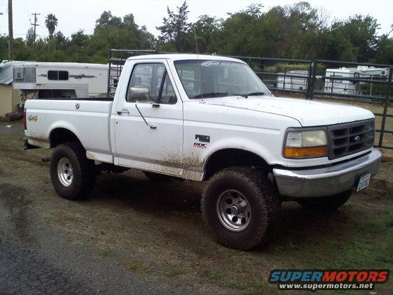 White Ford F-150 pickup truck parked on a dirt road