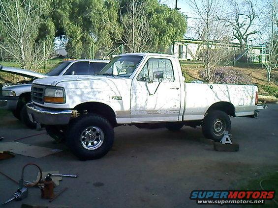White 1995 Ford F-150 pickup truck, side view, lifted suspension