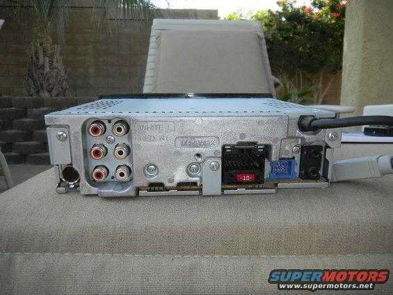 Rear panel of car stereo showing RCA inputs, fuse holder, and wiring connectors