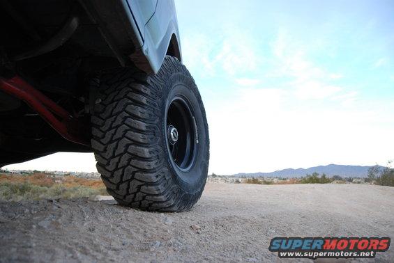 Off-road tire and red suspension components on a dirt surface