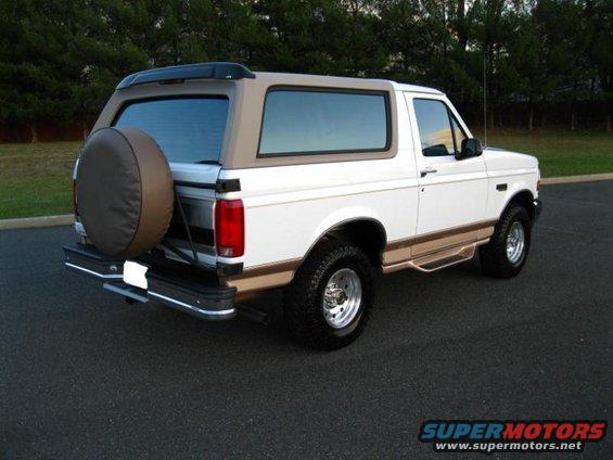 White 1996 Ford Bronco with tan top and spare tire on rear door