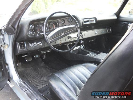 Black leather interior of a 1970 Chevrolet Camaro SS with a dashboard, steering wheel, and center console visible