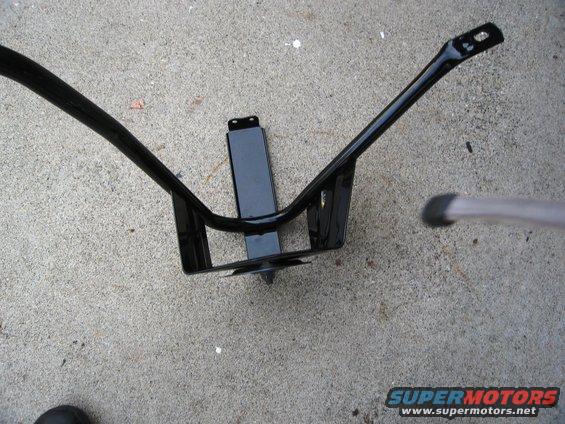 Black metal tire carrier mount assembly on concrete