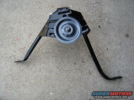 black metal bracket with a gray roller wheel on concrete