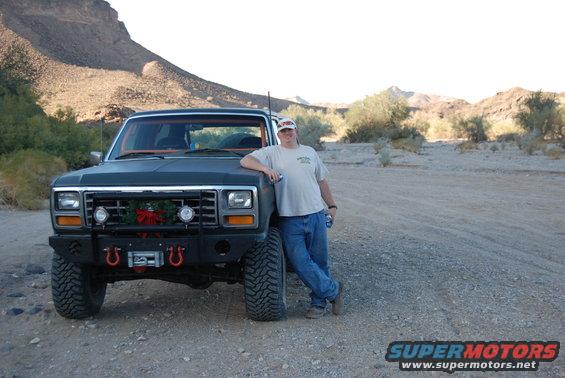 1982 Ford Bronco with aftermarket bumper and winch, parked in desert with a man leaning on it