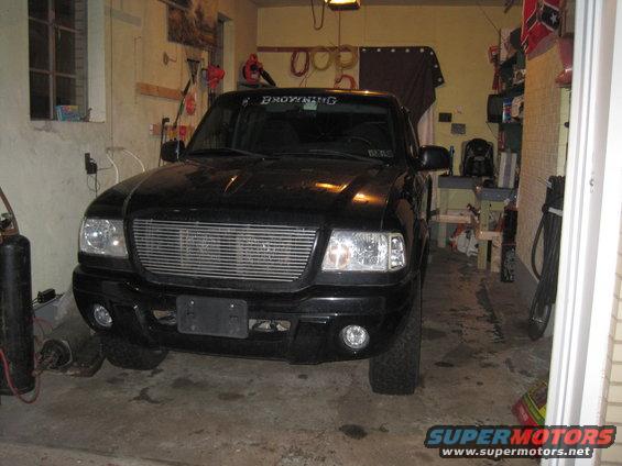 Black Ford Ranger parked in a garage, front view. Has a Browning sticker on the windshield