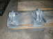 1995 Ford Bronco - Two gray metal brackets are shown resting on wooden planks, likely awaiting installation or painting.