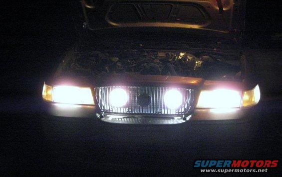 Front view of a 2000 Mercury Grand Marquis with headlights on and hood open