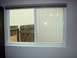 1989 Ford Bronco - View through a window shows a backyard with a wooden fence and vertical siding.