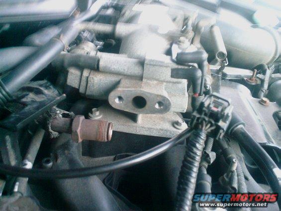 Engine part with hoses and wiring, close-up view