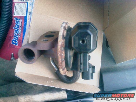 EGR valve with black plastic actuator and rusty metal flange