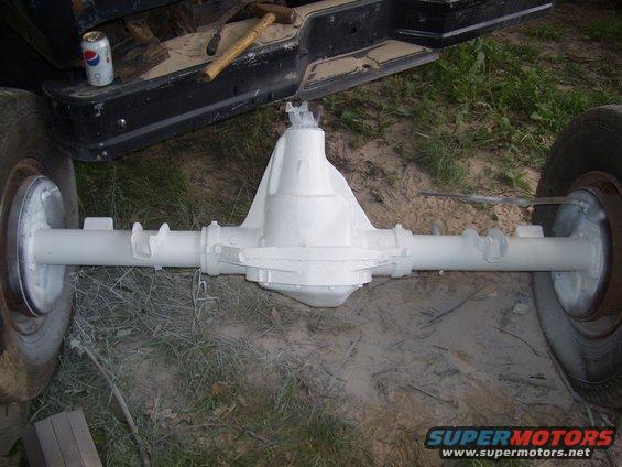 White painted rear axle assembly with brake drums and tires attached