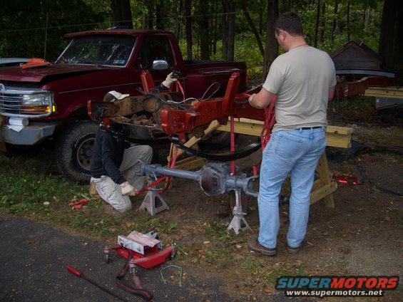 1992 Ford F-150 truck with front end disassembled, people working on chassis and axle