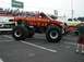 1994 Ford Bronco - A monster truck event with multiple custom trucks on display and spectators in the background.