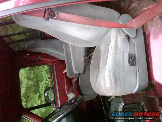 Interior of a 1992 Ford F-150 showing light gray seats and red trim