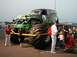 1994 Ford Bronco - Monster truck with custom paint and large tires is on display with onlookers.
