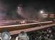 1994 Ford Bronco - Drag racing event at night with two trucks competing on the strip.