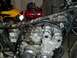 1980 Honda CB750 - Close-up of a motorcycle's engine and frame, with other vehicles and equipment visible.