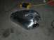 1980 Honda CB750 - A bare metal motorcycle fuel tank sits on a concrete floor, with electrical cords and a charger in the background.