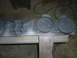 1995 Ford Bronco - Automotive parts, including brackets and circular components, are laid out on a wooden surface.
