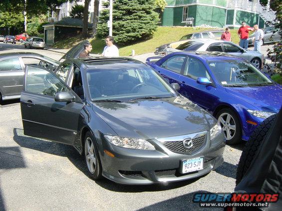 Dark gray 2003 Mazda 6 sedan with driver's door open, parked on street