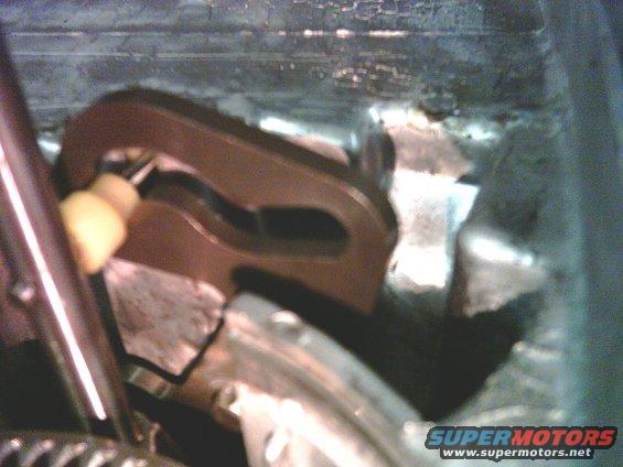 Close-up of a metal transfer case linkage mechanism with a yellow plastic component