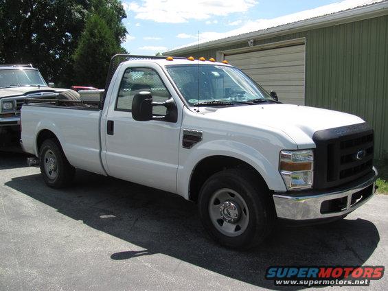 White Ford F-Series pickup truck parked next to an older SUV