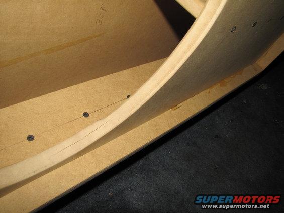 Wooden enclosure with visible screws and a crack in the wood