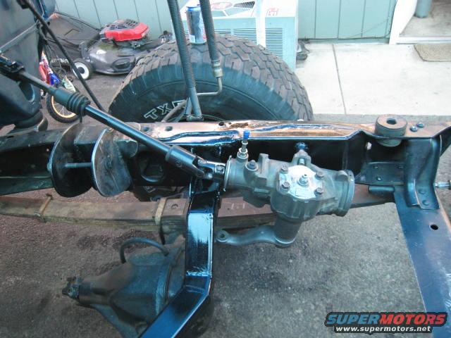 Close-up of a vehicle's frame, steering box, and part of a tire