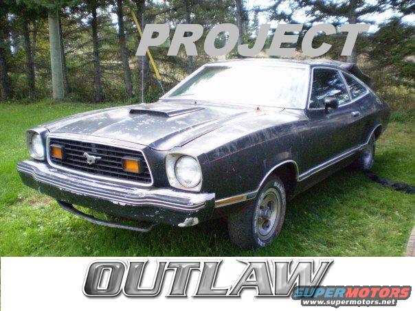 Black 1978 Ford Mustang II coupe with hood scoop parked on grass