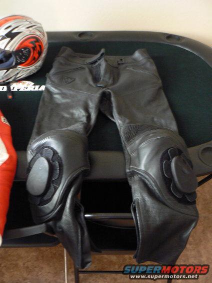 Black motorcycle riding pants with knee pads and a helmet
