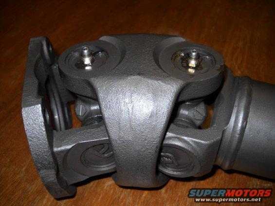 Driveshaft universal joint with grease fittings, on a wooden surface