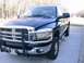 2006 Dodge 2500 - Front 3/4 view of a blue Dodge pickup truck with a chrome grille guard. The truck is parked on a concrete surface outdoors.