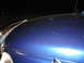 2006 Dodge 2500 - The hood of a blue vehicle shows many fine scratches and debris under artificial light.
