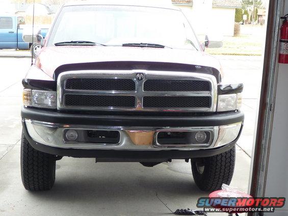 1997 Dodge 2500 front view, showing grille and headlights. Blue truck visible in background