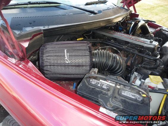 Red 1997 Dodge 2500 engine bay with aftermarket air filter and battery