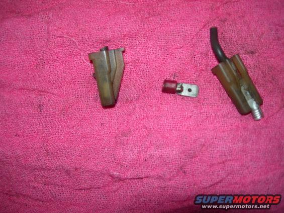 Two electrical connectors and a wire terminal on a pink cloth