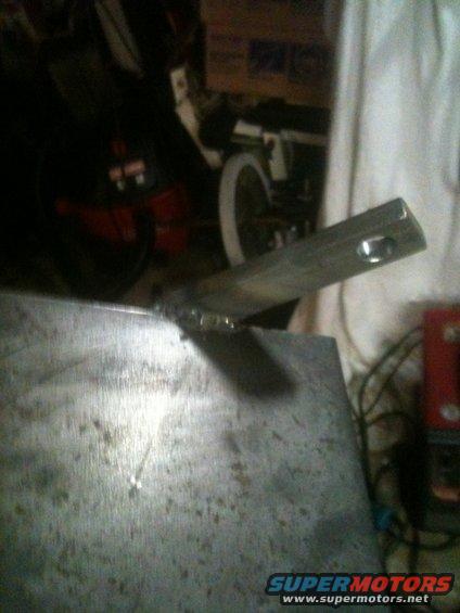 Welded metal part with a hole, Supermotors.net logo visible