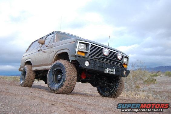 Gray modified SUV with large tires and winch, front 3/4 view